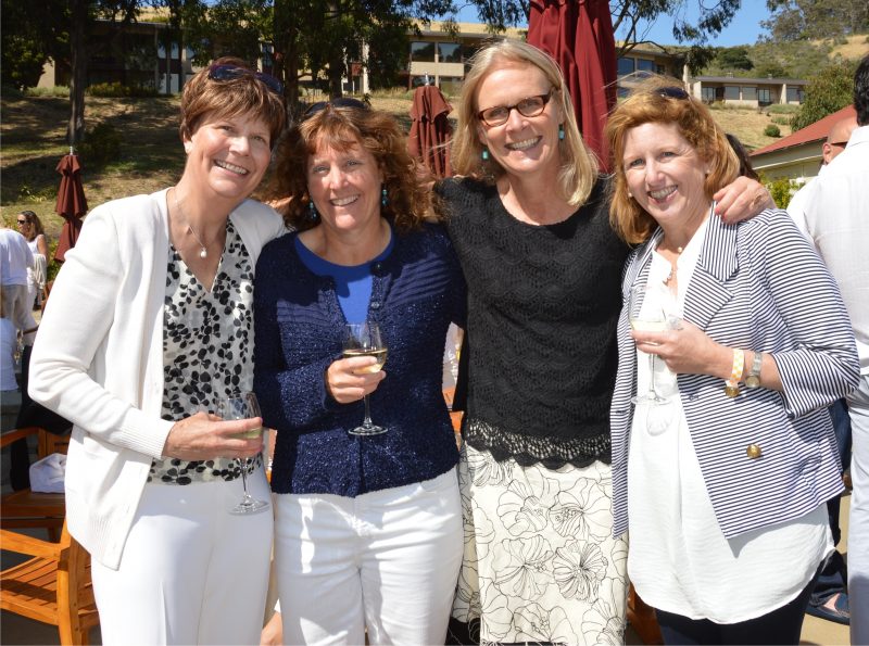 an image of Margo standing with 3 of her female friends on a sunny day, all holding wine glasses at an outdoor event