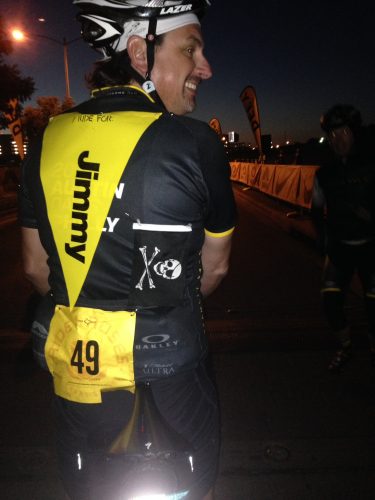 Jeff Mulder on his bicycle wearing an "I ride for Jimmy" flag down his back