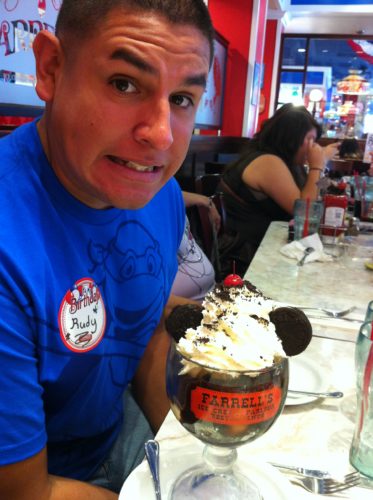 Rudy, wearing a blue t-shirt and nametag, about to eat a Farrell's ice cream sundae on his birthday