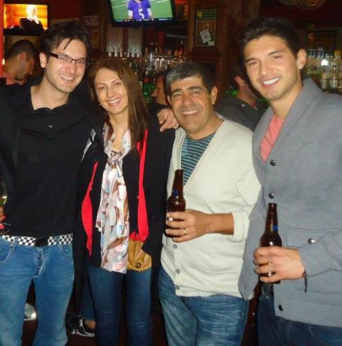 Daniel wearing glass in a black tshirt and jeans; Ana wearing a print shirt, black jacket with red stripe and jeans; Osvaldo wearing a white sweater jacket and jeans and Alejandro wearing a gray jacket and jeans