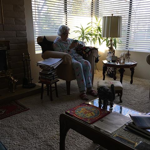 The author's mother in her Gold River house, sitting in an arm chair reading