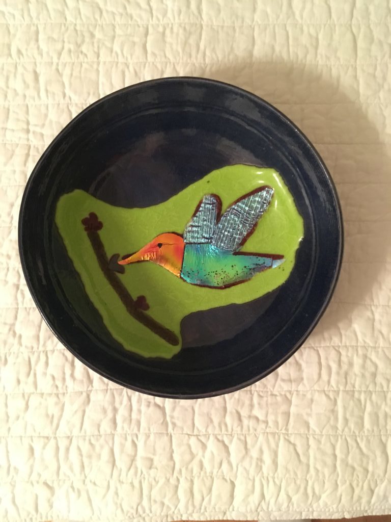 Glass plate with hummingbird on it made by Laura's father. The hummingbird has an orange head, turquoise body and shimmery blue wings
