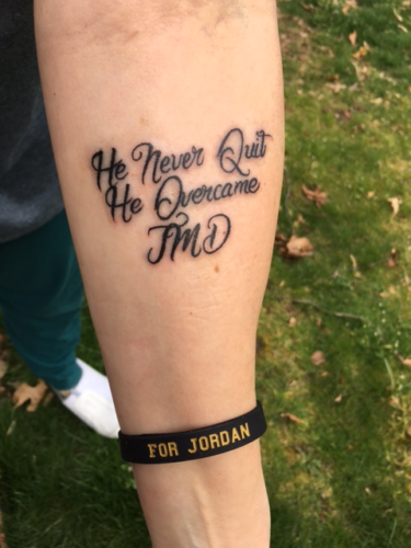 Bambi's tattoo on her fore arm -- "He never quit He overcame JMD . Bambi is also wearing a black "For Jordan" wristband. For Jordan is written in yellow.